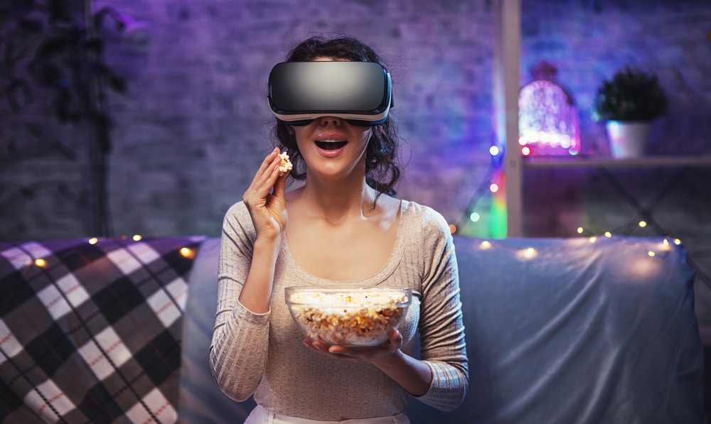 djevojka gleda VR filmove uz kokice i VR naočale